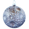 Julekugle formet som en måne med krater markeret med sølvglitter. Ornamentet er lavet i mundblæst glas.